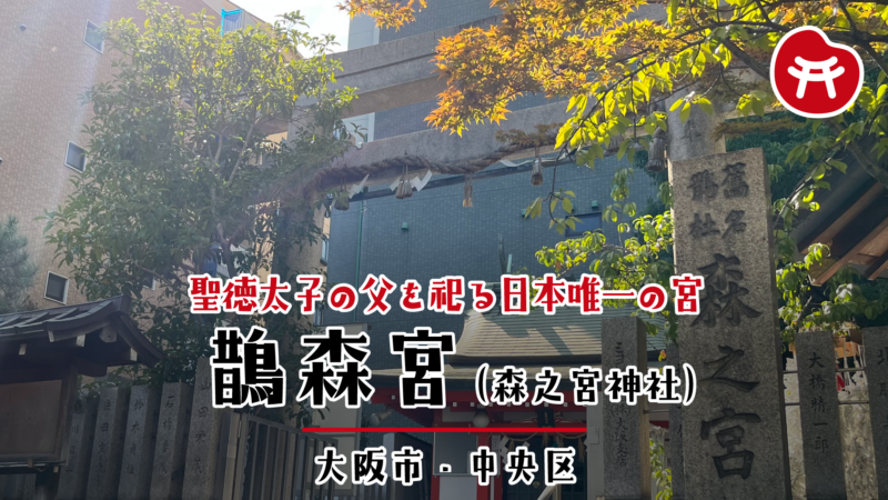 鵲森宮の石の鳥居としめ縄、右手に「森之宮」と刻まれた社号標、奥に朱色の社殿と背後のビル