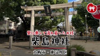 柴島神社の石の鳥居と、その奥に広がる公園と大きな木。鳥居の扁額に「柴島神社」の文字